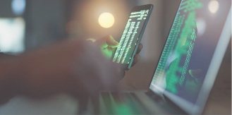 Dark room with laptops and computer code